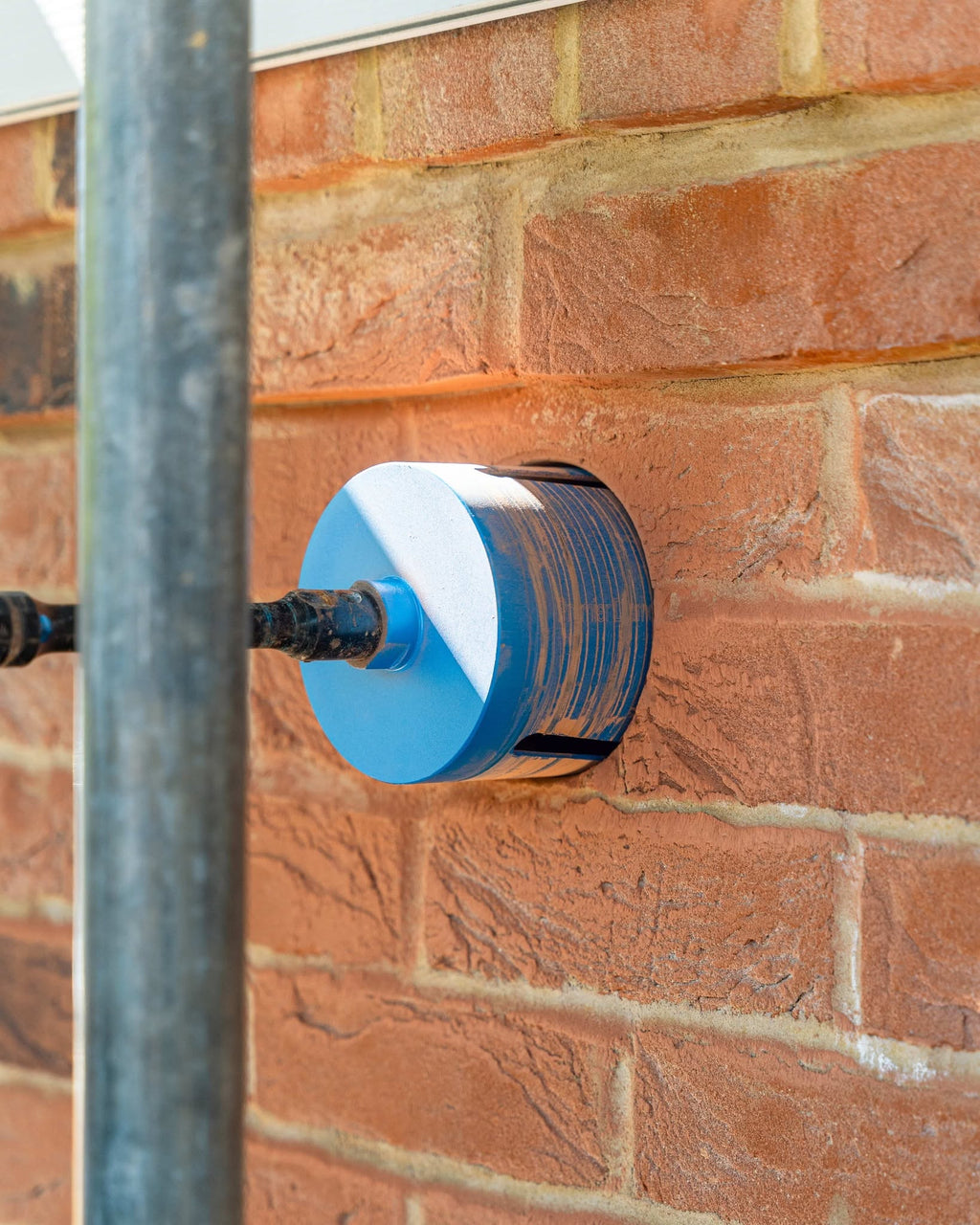 Blue dry diamond core bit drilling through brickwork on site