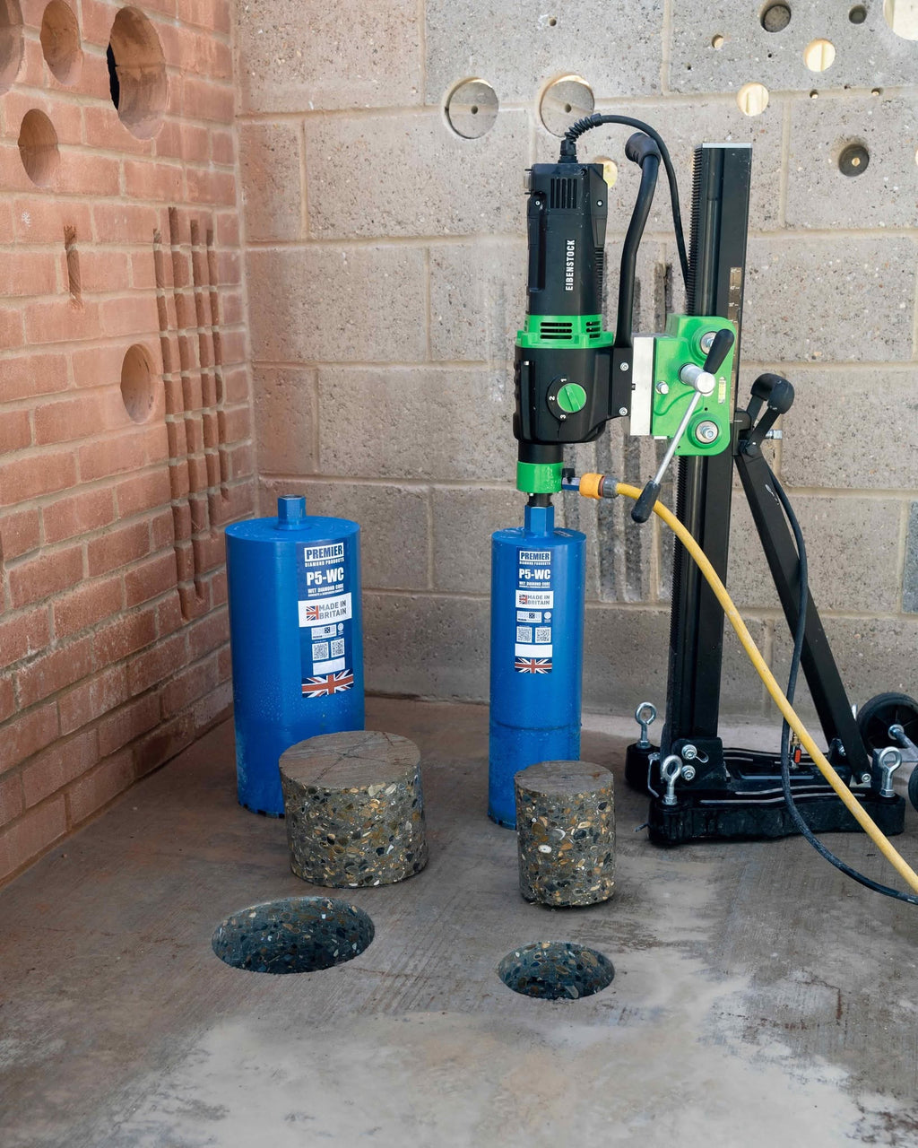 Premier P5-WC wet diamond core bits in use on a rig-mounted core drill, with cut concrete cores and drilled holes