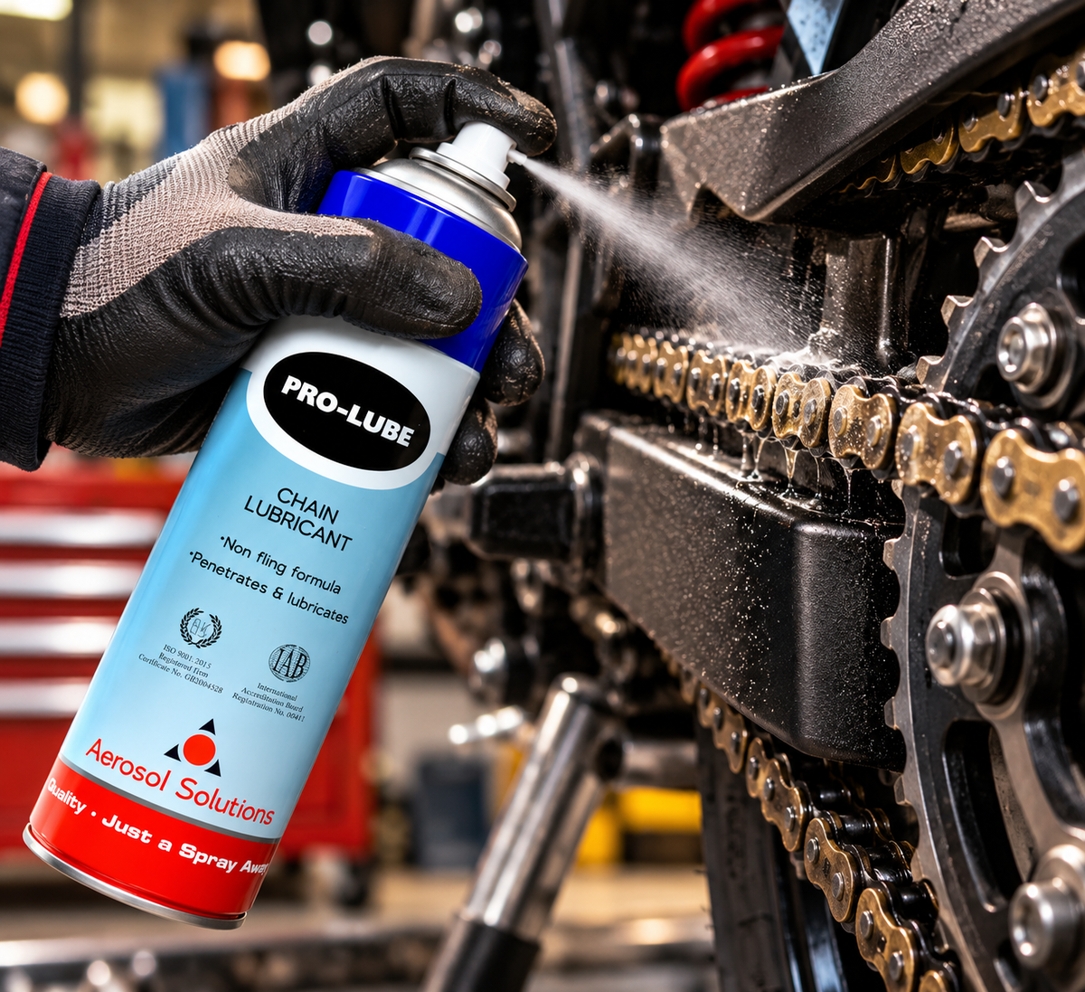 Aerosol Solutions Pro-Lube Chain Lubricant 500ml being sprayed onto a motorcycle drive chain
