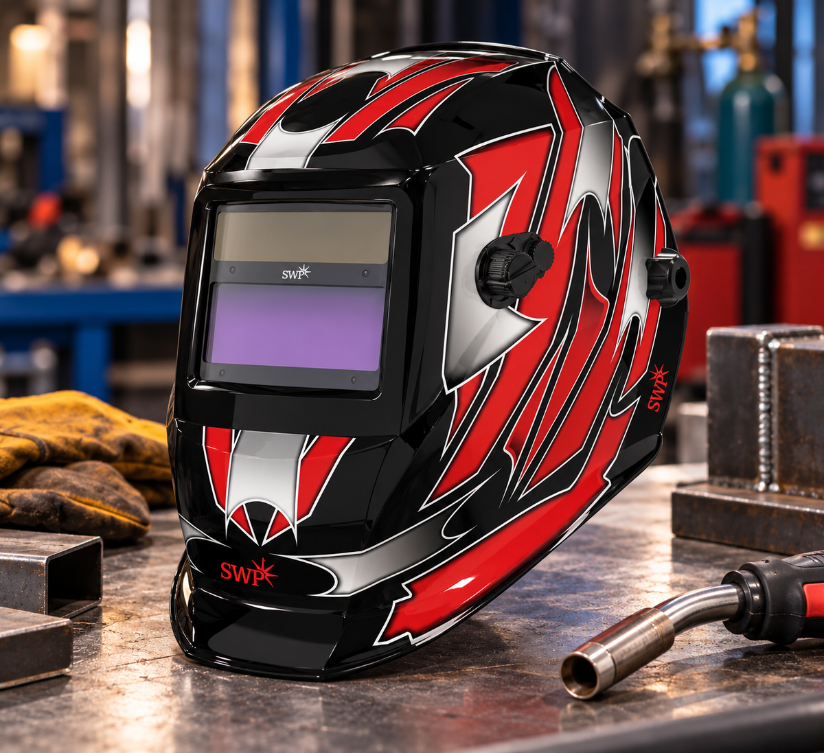 SWP black and red auto-darkening welding helmet showing front viewing window and side graphics on a workshop bench